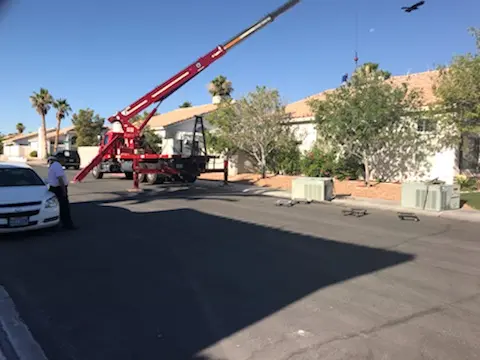 Crane truck delivering HVAC equipment in Las Vegas neighborhood