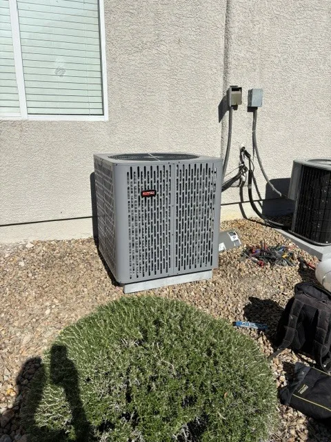 Residential AC condenser installation alongside Las Vegas home